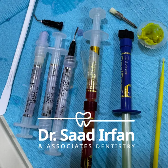 Composite restorative materials and bonding syringes laid out chairside at the DHA Phase 5 clinic
