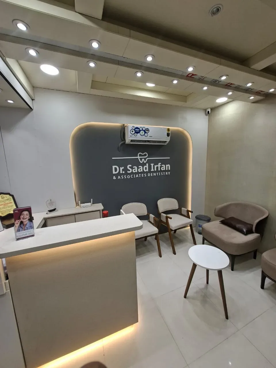 Reception counter and branded wall at the Clifton Block 9 dental clinic, Karachi