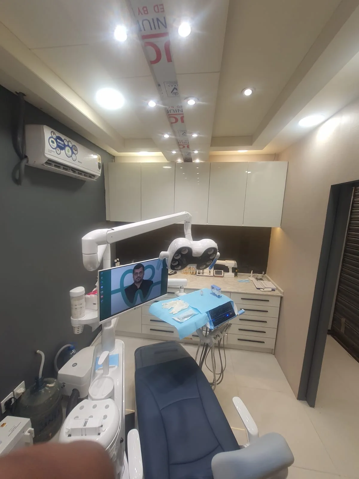 Treatment room at the Clifton Block 9 dental clinic with the dental chair, overhead light and chairside monitor, Karachi